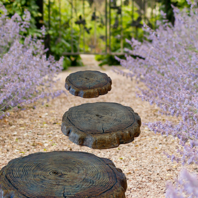 Set of log-style stepping stones arranged along a garden pathway, creating a rustic, natural look with a lush green background.